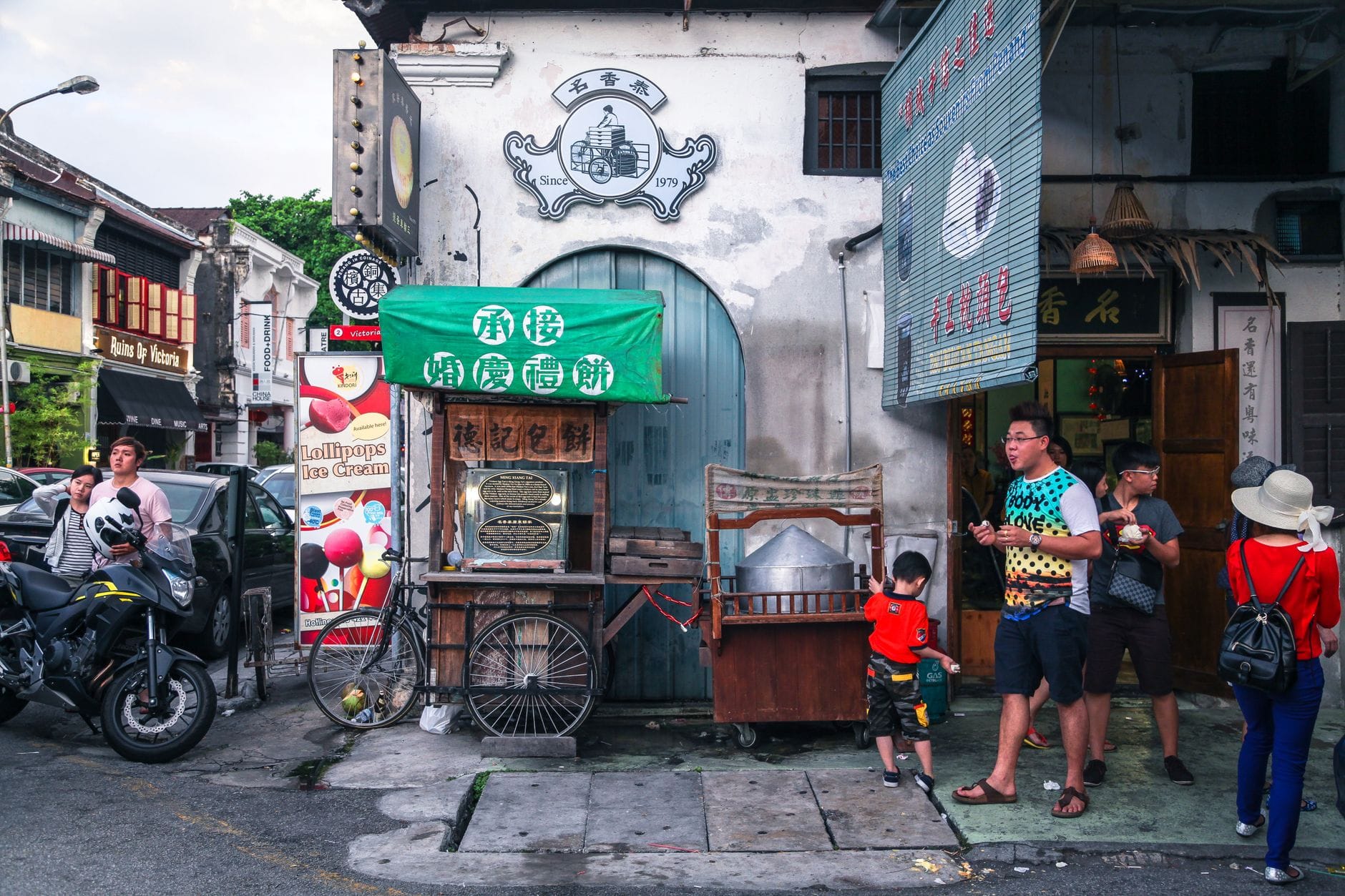 Nocny street food w Penang, stragany z jedzeniem i przechodnie